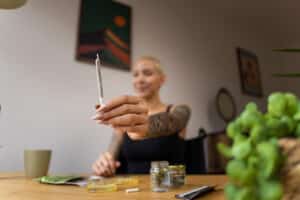 Young Caucasian woman in a wheelchair making a medical marijuana joint, to relieve her medical condition