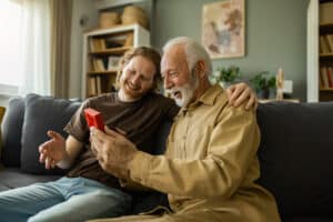 Grandfather and adult son smiling and celebrating at home