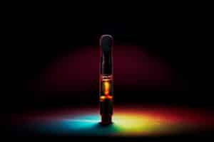 New Marijuana Vape Pen Cartridge with radiant rainbow lighting and dark background.